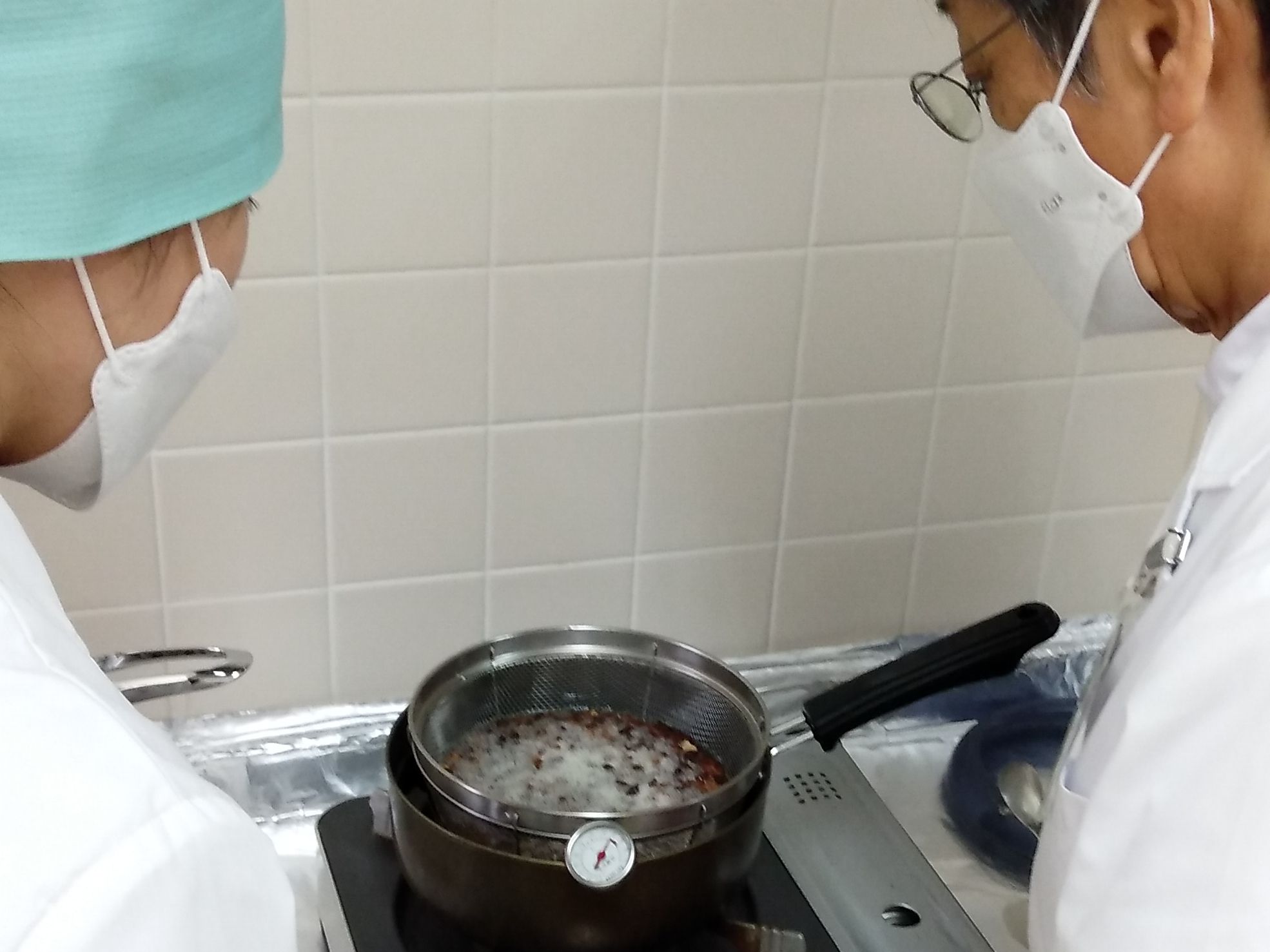 熱したゴマ油に生薬を投入し、時々かき混ぜながら徐々に温度を上げていきます